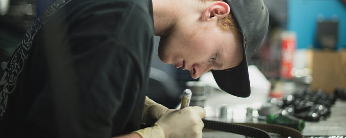 An employee in BWP Car Maintenance Service in Denver, CO repairs some detail with a screwdriver