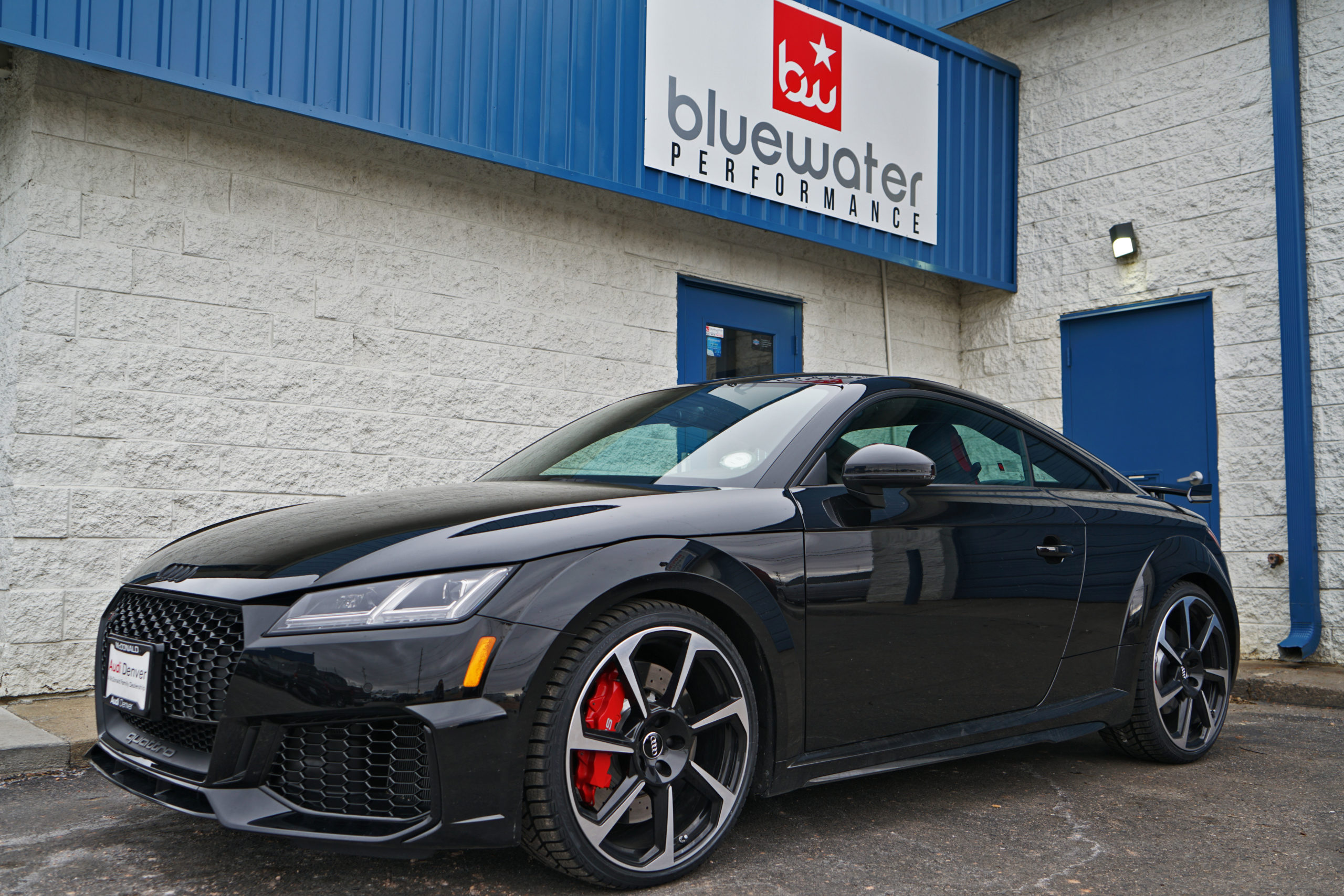 The picture shows a black Audi outside Bluewater Performance undergoing an Audi tire replacement.