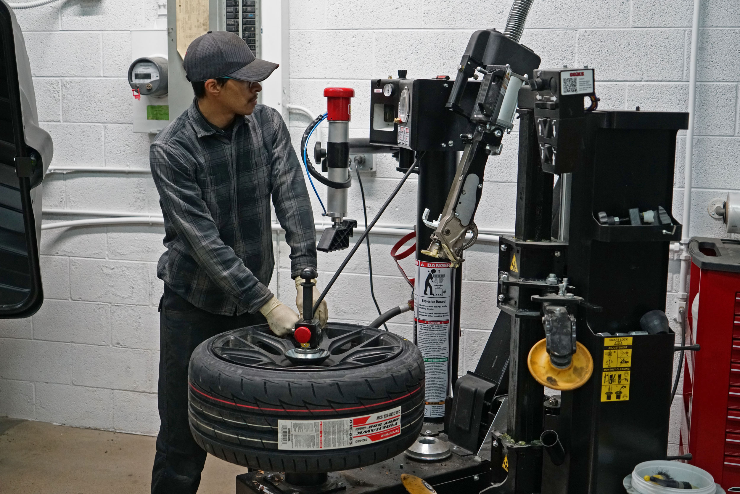 Image of a mechanic at bluewater Performance providing tire service in Denver, CO, fixing tires in the machine.