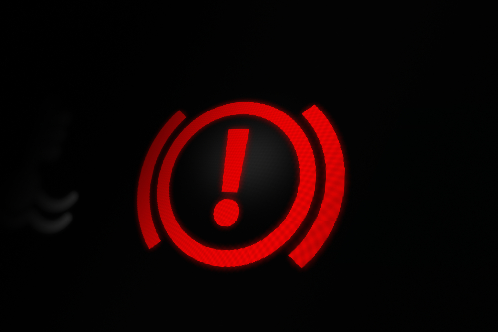 The handbrake warning lights on the BMW dashboard represent issues with the car's brake system.