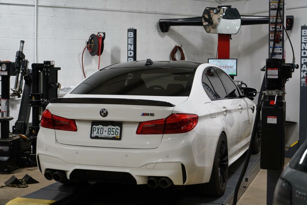 A white BMW in a service center; used BMW maintenance costs are higher compared to new ones.