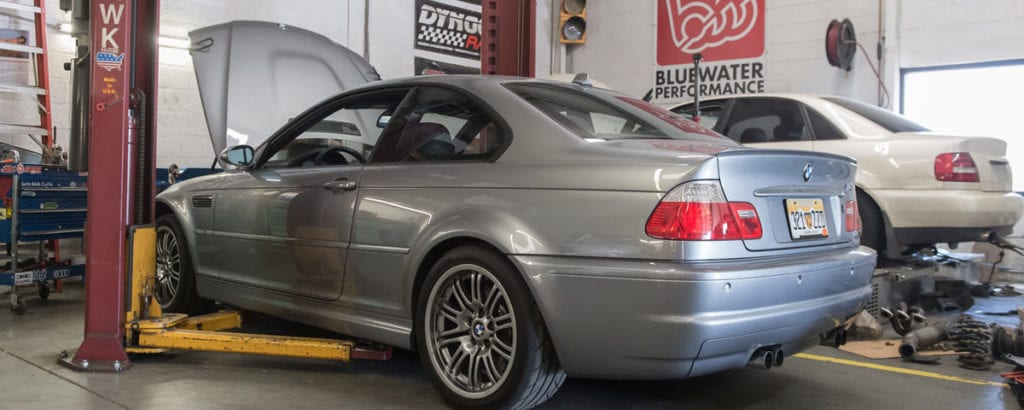 Grey-colored BMW car in a maintenance garage; our experts know how to remove oil filter housing.
