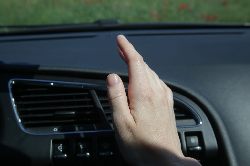 If the car's A/C is blowing hot air, fix it by refilling the refrigerant or checking the compressor.