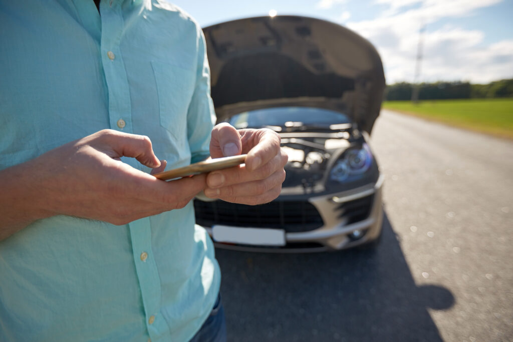 The man tries to call an auto repair shop urgently as his car unexpectedly enters limp mode.