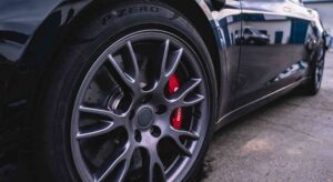 a titanium wheel with red calipers on a black sports car