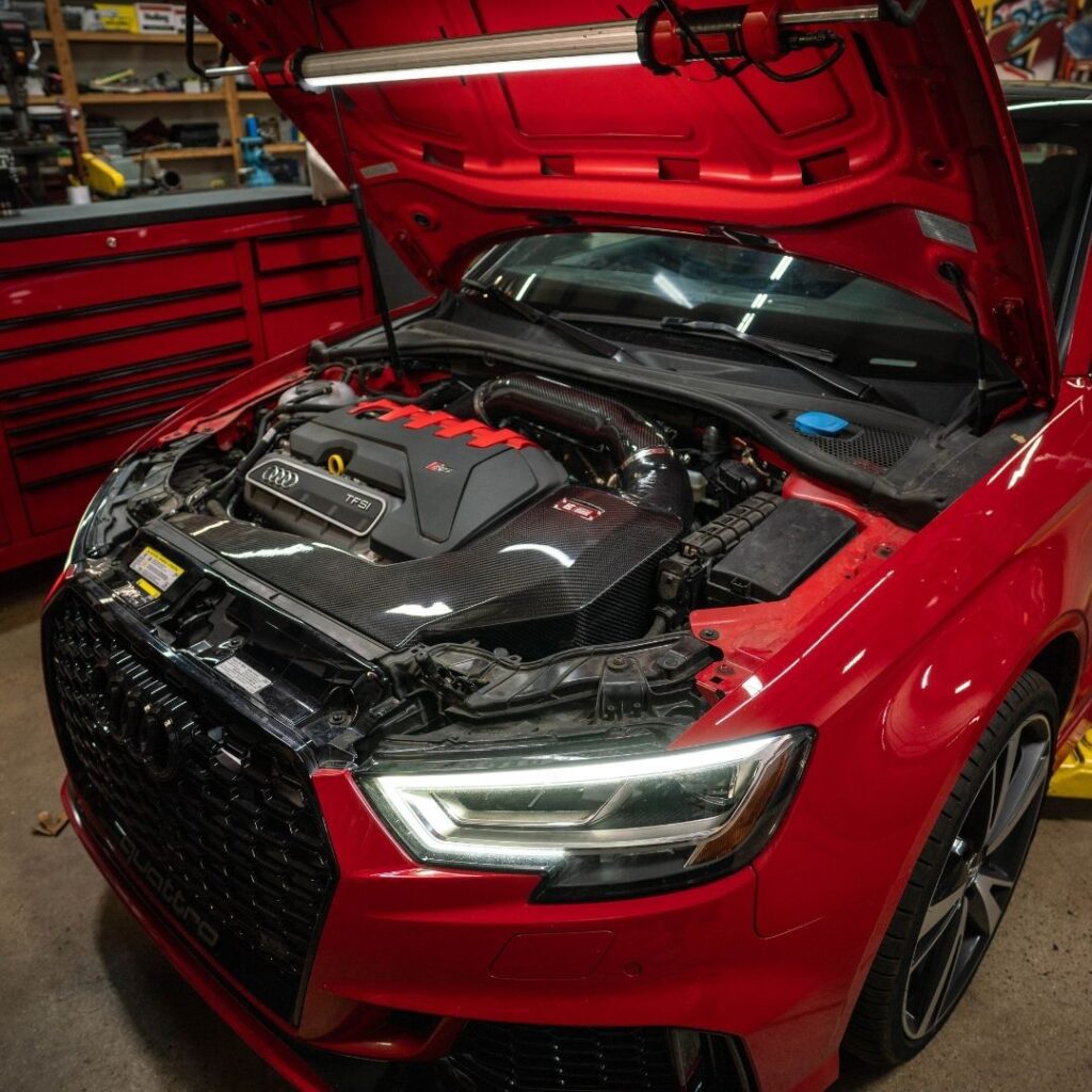 A pristine, newly installed vehicle battery inside a clean and dry luxury car engine bay.