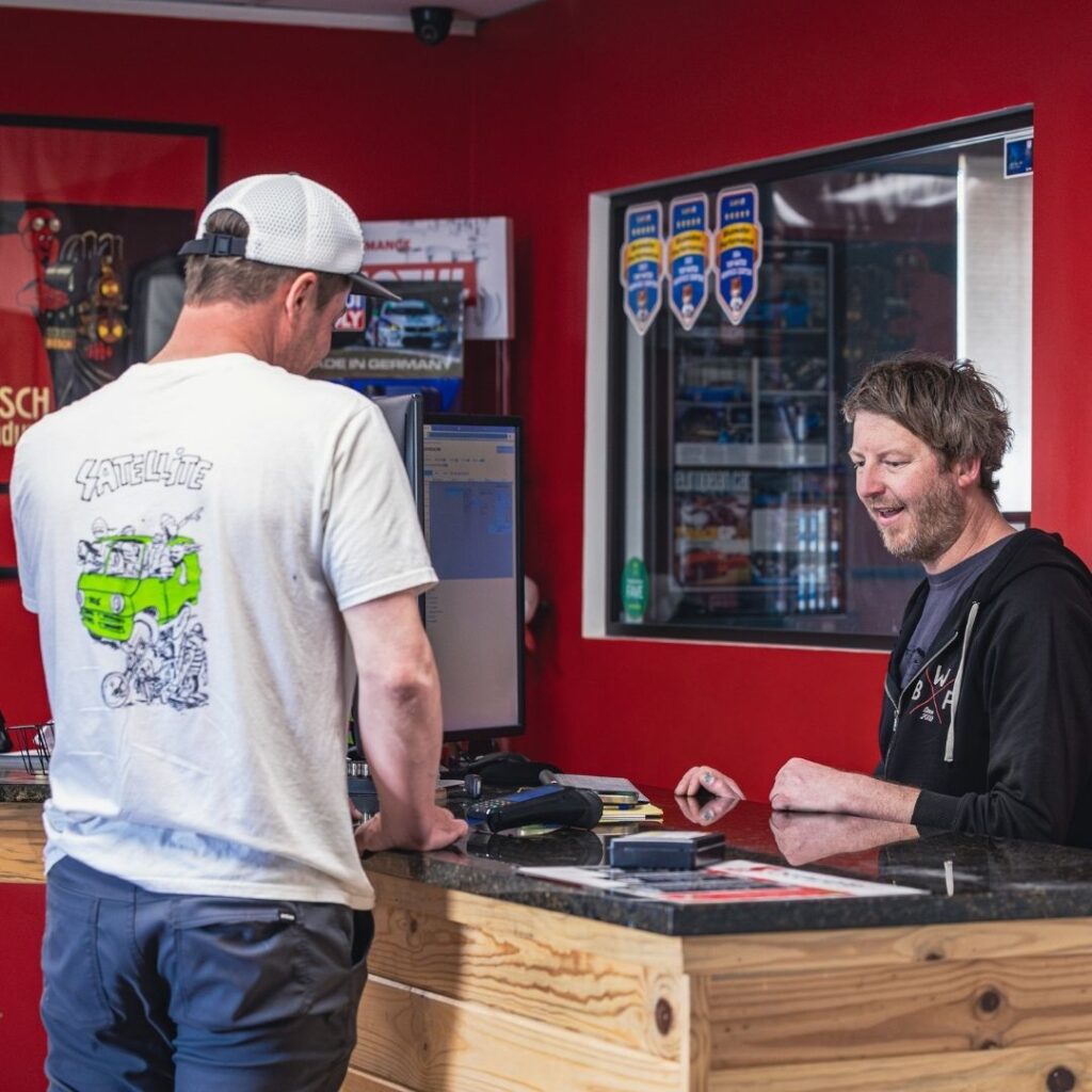 A friendly and transparent auto repair service discussion showing a digital checklist in a tidy customer lounge.