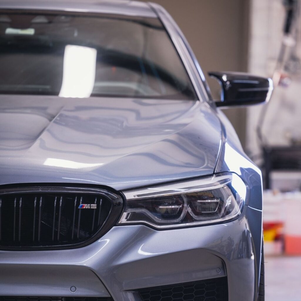 A spotless, freshly serviced luxury sedan parked in a clean, modern garage bay ready for the road.